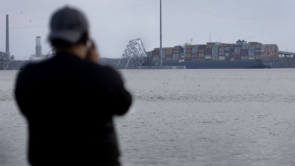 BALTIMORE, MARYLAND - MARCH 26: A man tries to photograph the cargo ship that hit and collapsed the Francis Scott Key Bridge on March 26, 2024 in Baltimore, Maryland. According to reports, rescuers are still searching for multiple people, while two survivors have been pulled from the Patapsco River. A work crew was fixing potholes on the bridge, which is used by roughly 30,000 people each day, when the ship struck at around 1:30am on Tuesday morning. The accident has temporarily closed the Port of Baltimore, one of the largest and busiest on the East Coast of the U.S. (Photo by Scott Olson/Getty Images)