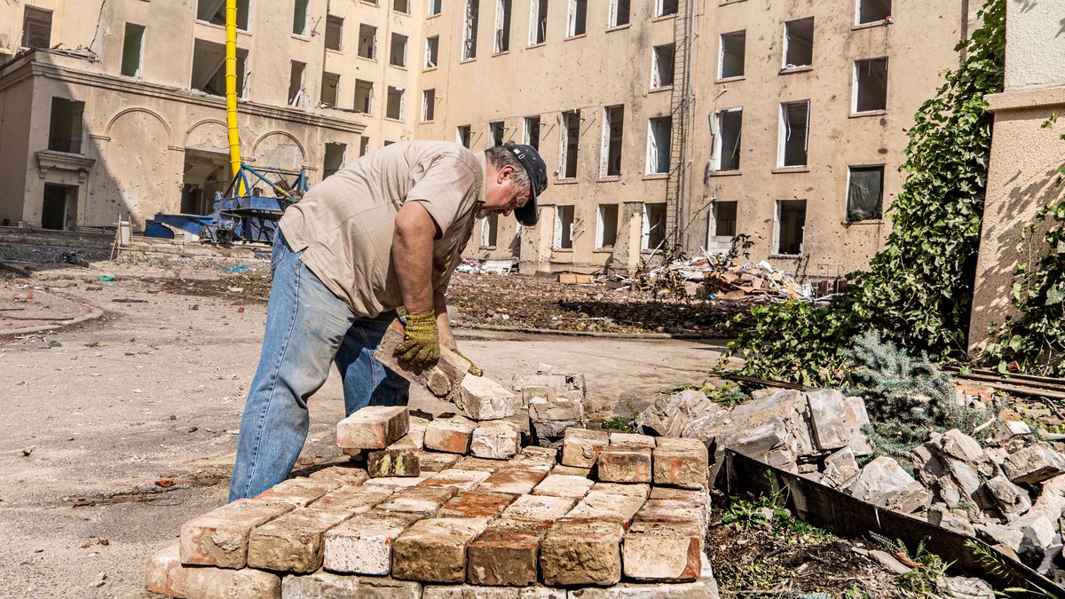 Charków, Ukraina, 29.08.2022. Mężczyzna usuwa zniszczenia przy zaatakowanym rosyjską rakietą budynku administracji państwowej w Charkowie, 29 bm. Trwa inwazja Rosji na Ukrainę. (ad) PAP/Mykola Kalyeniak