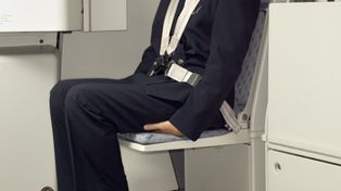 Dlaczego stewardesy siadają na dłoniach? Tłumaczymy, o co chodzi