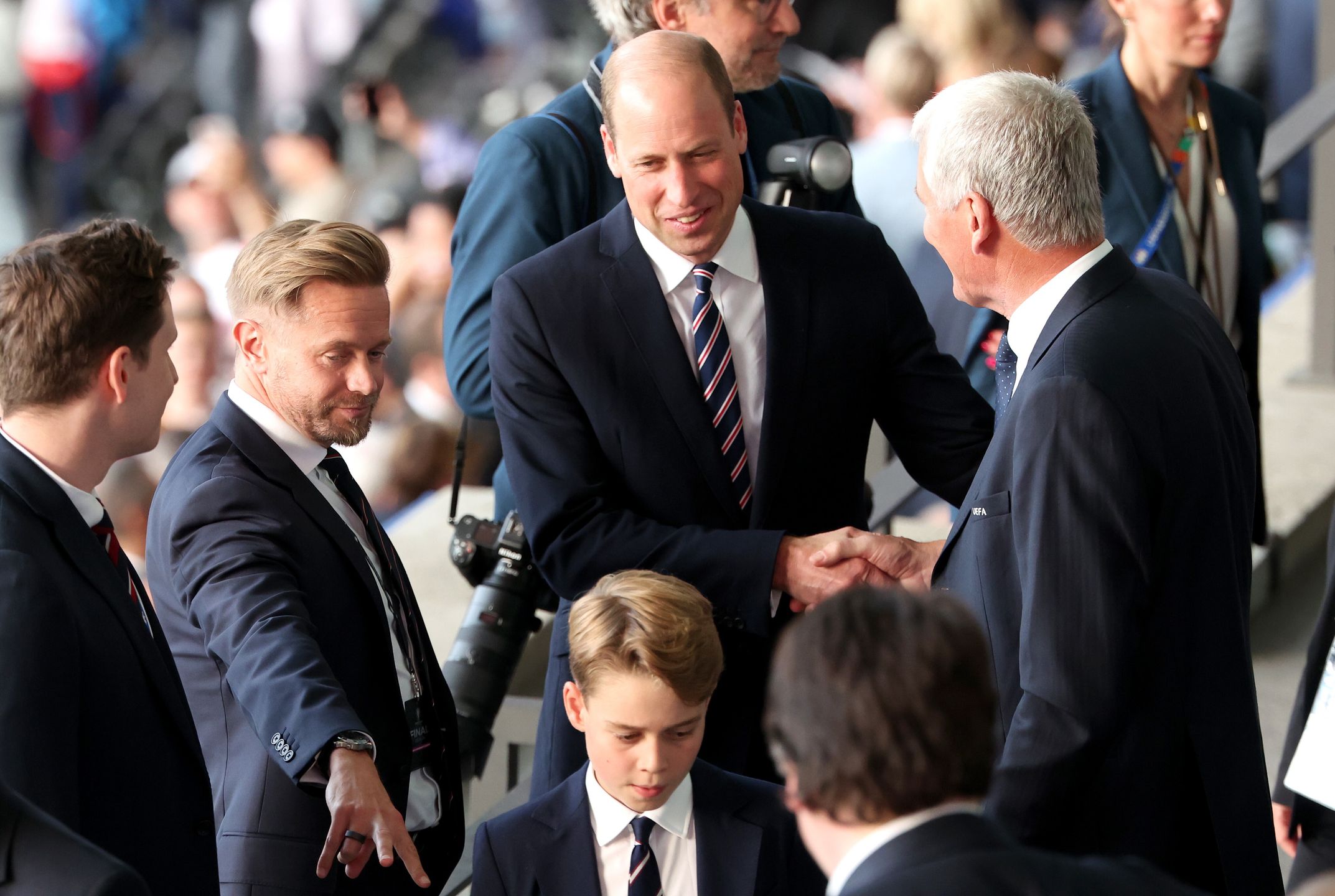 William (C), Prince of Wales, and his son Prince George of Wales are greeted by UEFA Executive Committee member David Gill as they arrive to their seats before the UEFA EURO 2024 final soccer match between Spain and England, in Berlin, Germany, 14 July 2024. EPA/GEORGI LICOVSKI Dostawca: PAP/EPA.