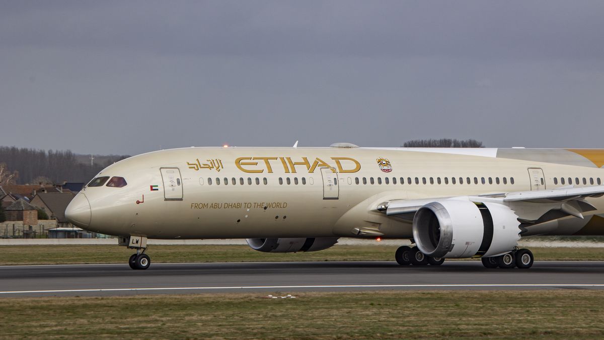 Close-up at the front section of the plane with the wings, jet engine, landing gear, cockpit and ETIHAD logo symbol. Etihad Airways Boeing 787-9 Dreamliner aircraft as seen on final approach flying, landing and taxiing at the Belgian capital, Brussels Airport Zaventem BRU. The  Boeing B787 modern and advanced wide-body passenger airplane has the registration A6-BLW and is powered by 2x GE jet engines. The plane is arriving at the European city from Abu Dhabi. Etihad is the second flag carrier of the United Arab Emirates UAE. The aviation industry and passenger traffic are phasing a difficult period with the Covid-19 coronavirus pandemic having a negative impact on the travel business industry with fears of the worsening situation due to the new Omicron variant mutation at the fifth wave. Brussels, Belgium on January 30, 2022 (Photo by Nicolas Economou/NurPhoto via Getty Images)