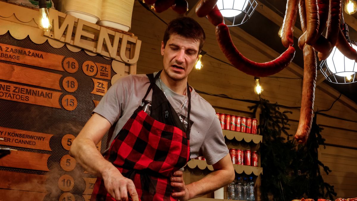 Sellers offer traditional Polish kielbasa and grilled meat as visitors walk the alleys of Krakow's Christmas Market, one of the largest such markets in Europe as it opened today with Christmas lights, fresh food and hot wine on the landmark Main Square of the Old Town of Krakow, Poland on November 29, 2024. (Photo by Dominika Zarzycka/NurPhoto via Getty Images)