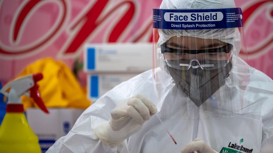 HANOI, VIETNAM - APRIL 18: A medical specialist in protective suit works on blood samples from vendors and labourers at Long Bien market for coronavirus disease (COVID-19) rapid test on April 18, 2020 in Hanoi, Vietnam. Hanoi conducts rapid tests at a number of wholesale markets throughout the city on April 18-19 in order to detect the potential spread of the novel coronavirus (COVID-19). The Coronavirus (COVID-19) pandemic has spread to many countries across the world, claiming over 150,000 lives and infecting over 2.2 million people. (Photo by Linh Pham/Getty Images)