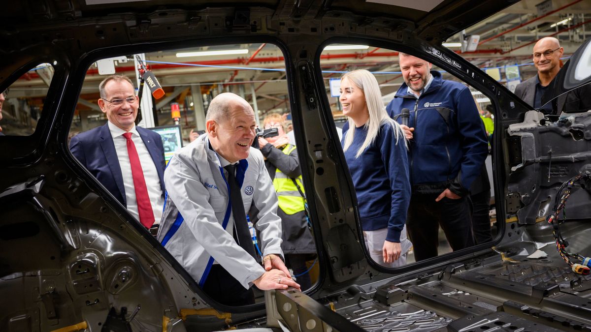 German Chancellor Olaf Scholz laughs after installing a part on the inside of the frame of a model ID.7 while an employees look over his shoulder during his visit at the Volkswagen factory in Emden, Germany, 18 February 2025. EPA/GREGOR FISCHER Dostawca: PAP/EPA.