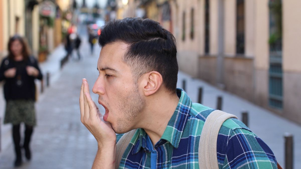 Man checking his own breathMan checking his own breath.ajr_images