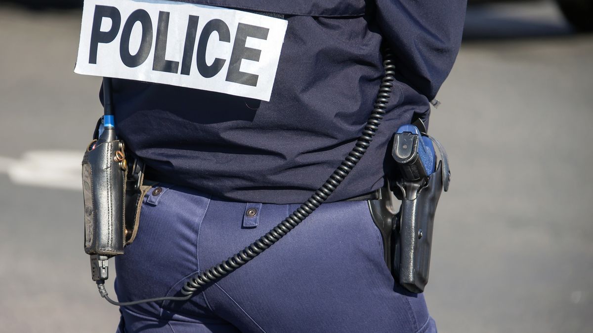 Back of the police officer with the inscription "POLICE" with a gun and a walkie-talkie.The back of the police officer with the inscription "POLICE" with a gun and a walkie-talkie. French policeman in outfit, view from the back on the street of Paris. France,???? ??????