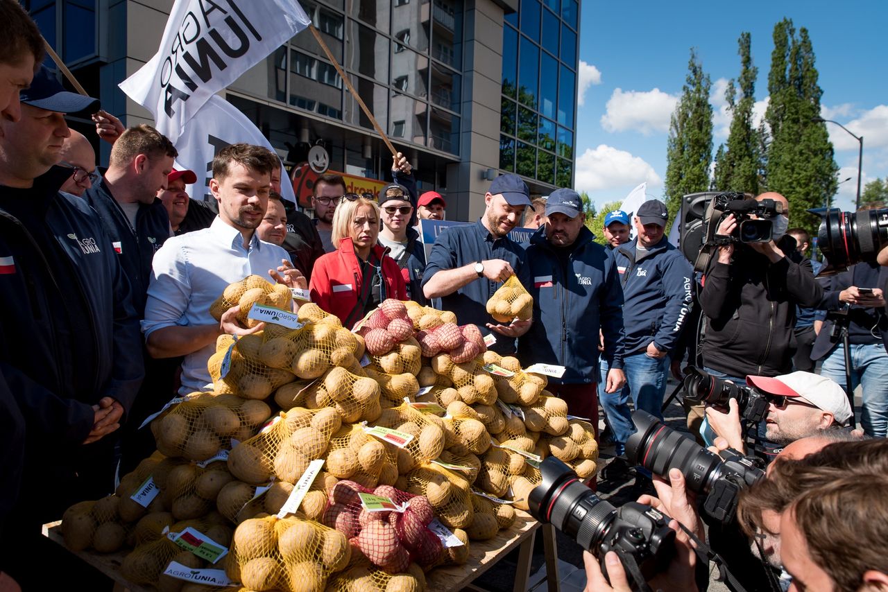 Michał Kołodziejczak na proteście pod hasłem "Agrounia odbije wieś PiSowi" rozdaje ziemniaki pod sklepem