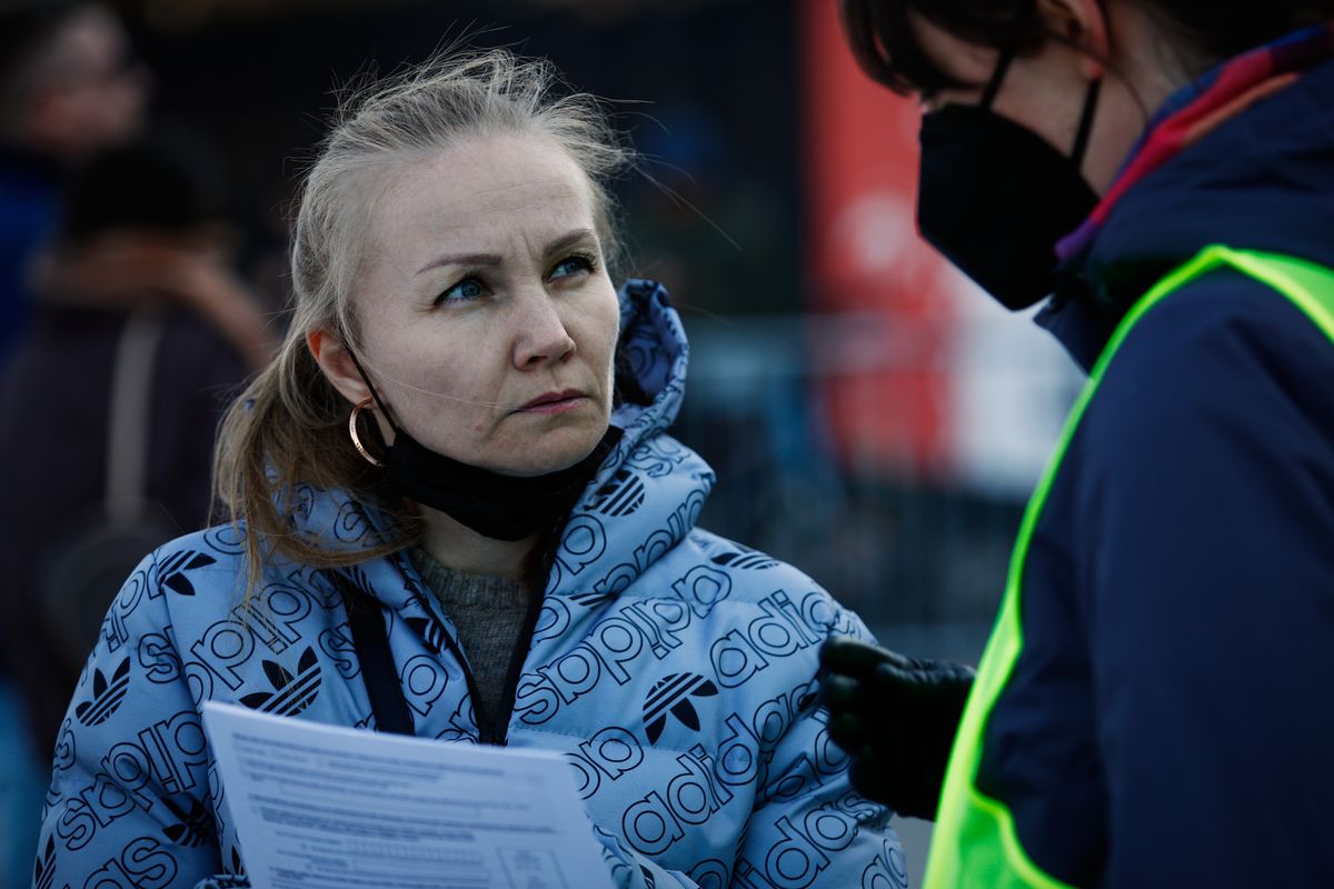 A woman listens to a volunteer while holding a registry form to apply for a PESEL, the Polish social security number in Warsaw, Poland on 19 March, 2022. (Photo by STR/NurPhoto via Getty Images)