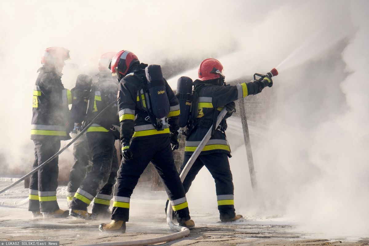 Lwówek. Pożar domu w centrum miasta. Strażacy walczą o ocalenie sąsiednich budynków