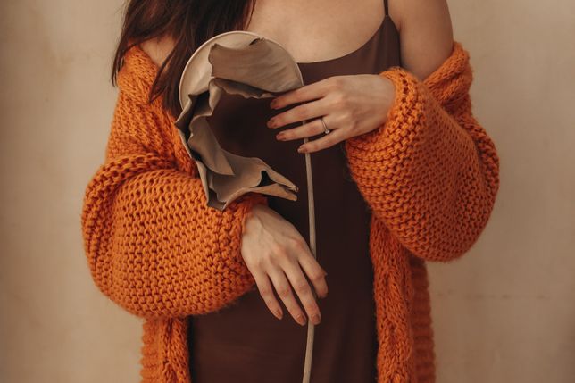 Cropped female body in an orange knitted cozy cardigan holding a beige dry plant. Autumn aesthetic details.KAPRIS_KSENIAcozy, autumn, orange, knitted, cardigan, female, hands, dry, plant, details, sweater, fall, thanksgiving, fashion, clothes, textile, lifestyle, concept, cloth, fabric, casual, comfort, beige, woman, season, october, feminine, november, warm, hugge, jumper, home, hold, brown, holding, retro, vintage, rustic, elegant, seasonal, clothing, wool, copy space, dried, caucasian, comfortable, texture, autumnal, hygge, inspiration