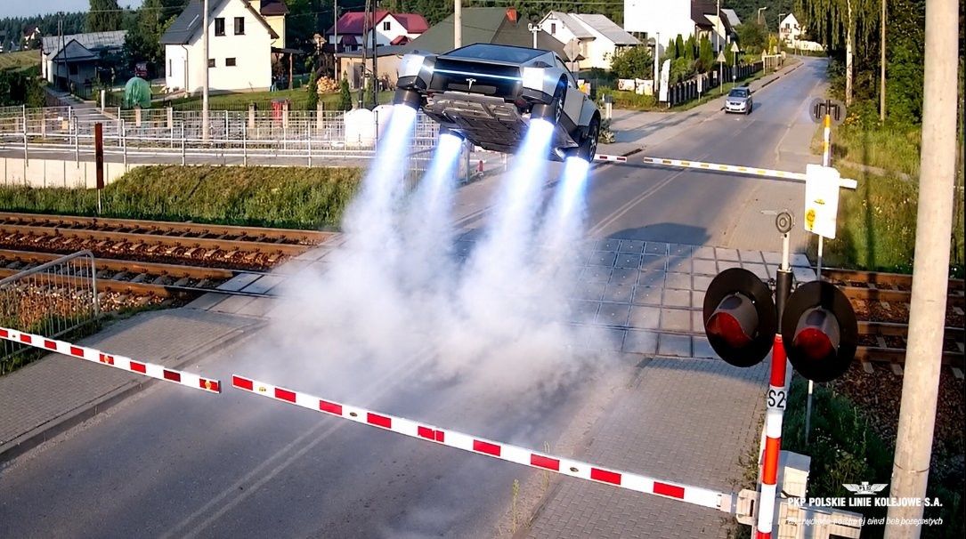 Tesla Roadster omijająca rogatki na przejeździe kolejowym