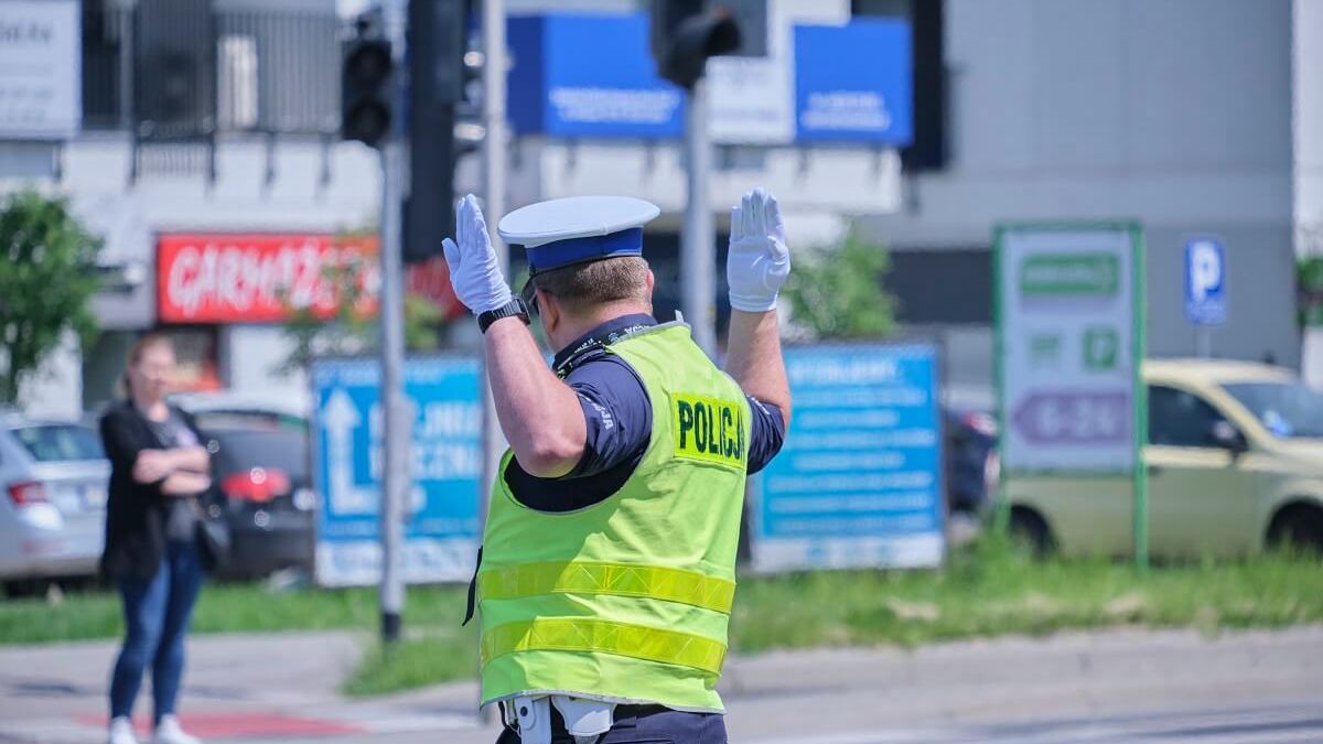 Policjant kierujący ruchem na skrzyżowaniu z wyłączoną sygnalizacją świetlną