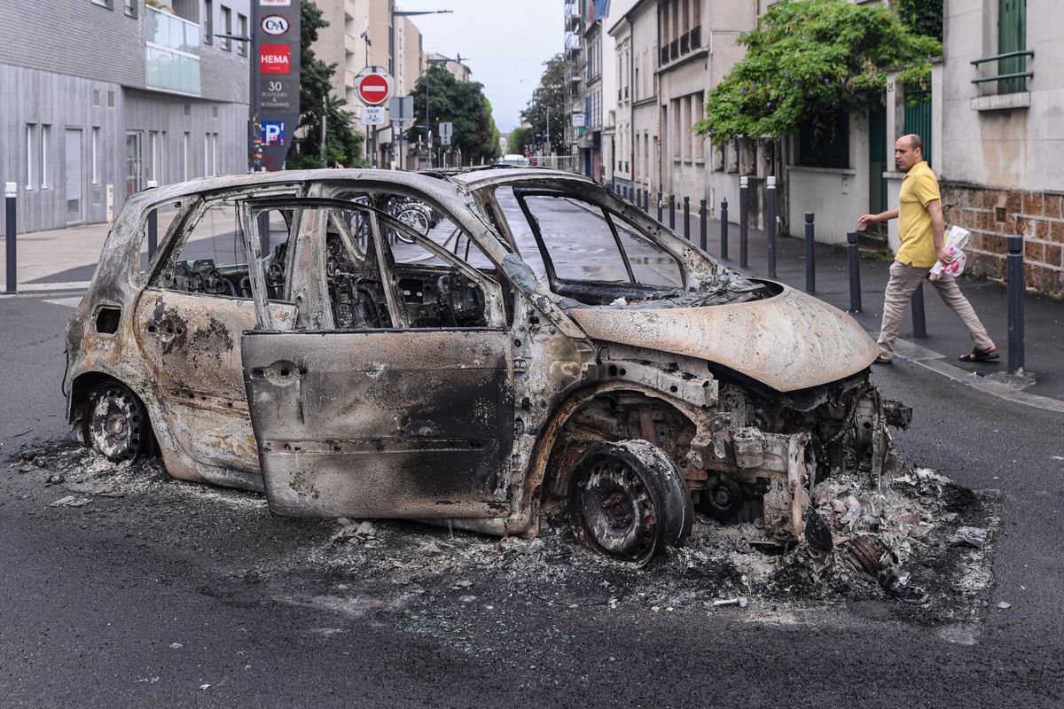 Doszczętnie spalony samochód po zamieszkach w Paryżu