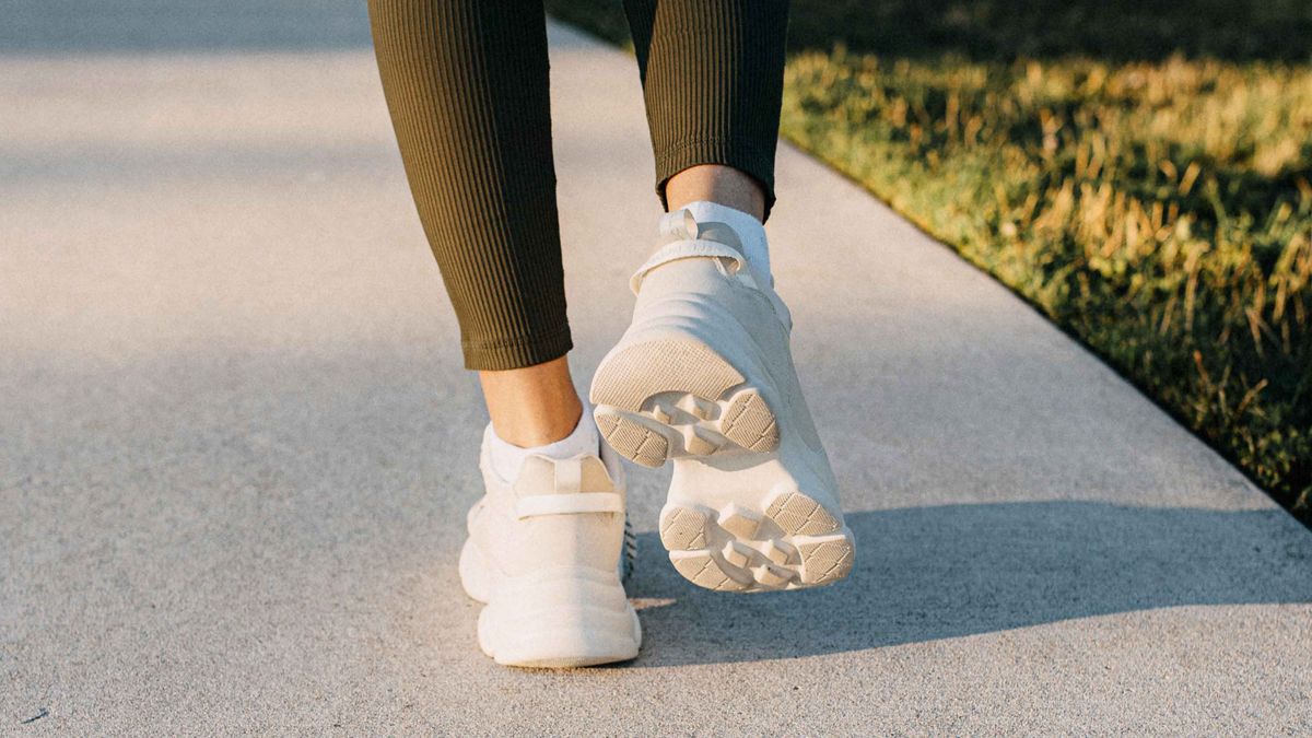 Woman's feet walking on a sunlit pathway, wearing white sport shoes
A woman is walking on a sunlit pathway, wearing white sneakers and green leggings. The sunlight casts a warm glow on the path and the surrounding grass.
Stefania Pelfini la Waziya