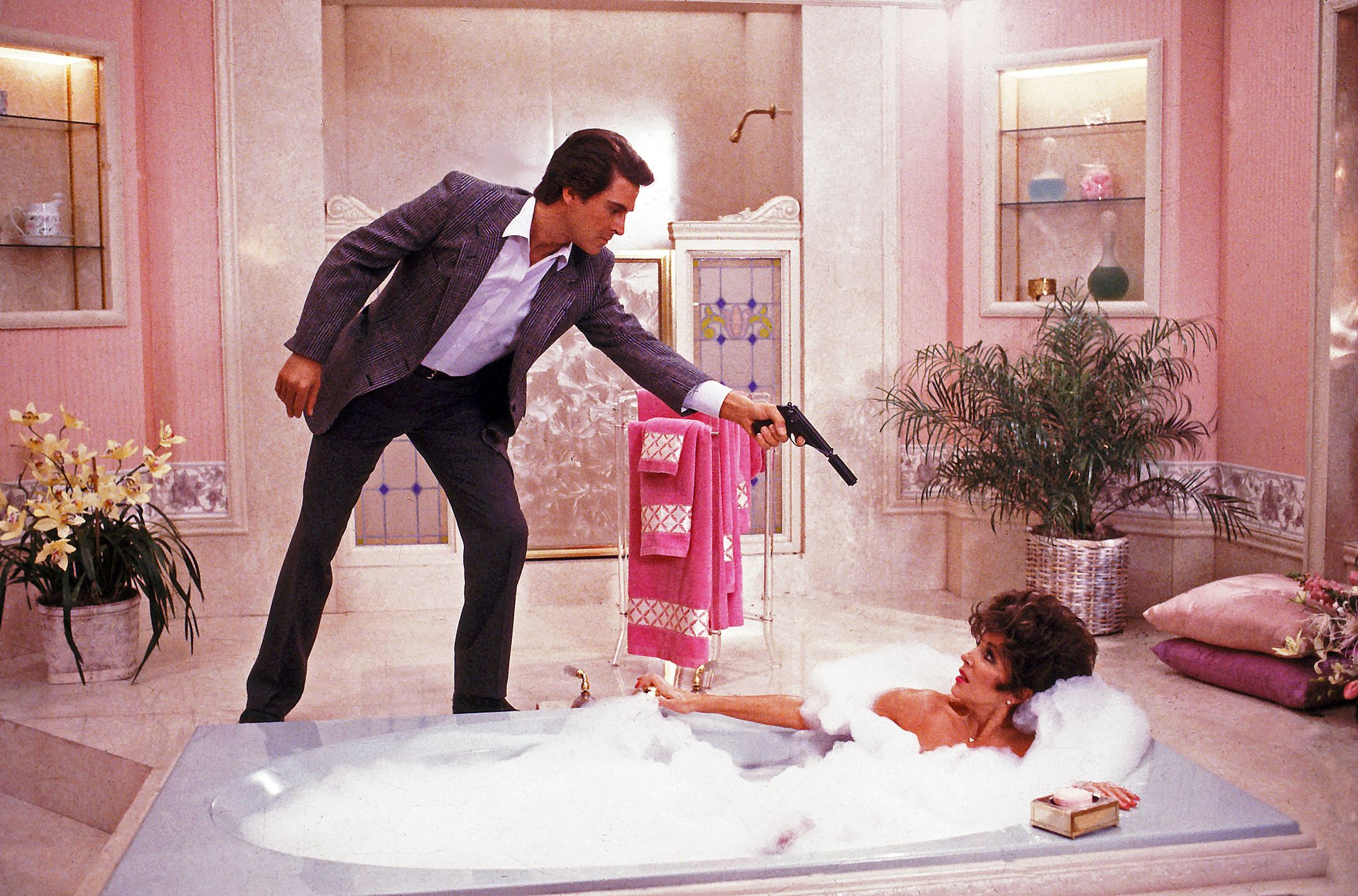 Colorado RouletteSean Rowan, played by James Healey, threatens Alexis Carrington (Joan Collins) with a gun while she is taking a bubble bath in 'Colorado Roulette', the final episode of Season 8 of the American TV soap opera 'Dynasty', first aired 30th March 1988.  (Photo by Eddie Sanderson/Getty Images).eddie sanderson