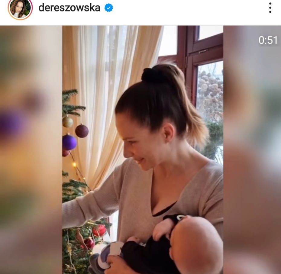 Anna Dereszowska z synkiem na rękach stroi choinkę