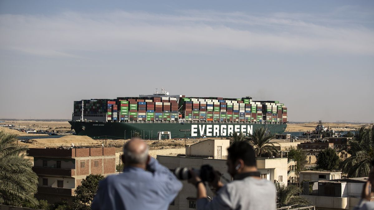 SUEZ, EGYPT - MARCH 29: People watch as the container ship 'Ever Given' is refloated, unblocking the Suez Canal on March 29, 2021 in Suez, Egypt. This morning the container ship came partly unstuck from the shoreline, where it ran aground in the canal last Tuesday, and later resumed its course shortly after 3pm local time. The Suez Canal is one of the world's busiest shipping lanes and the blockage had created a backlog of vessels at either end, raising concerns over the impact on global shipping and supply chains. (Photo by Mahmoud Khaled/Getty Images)