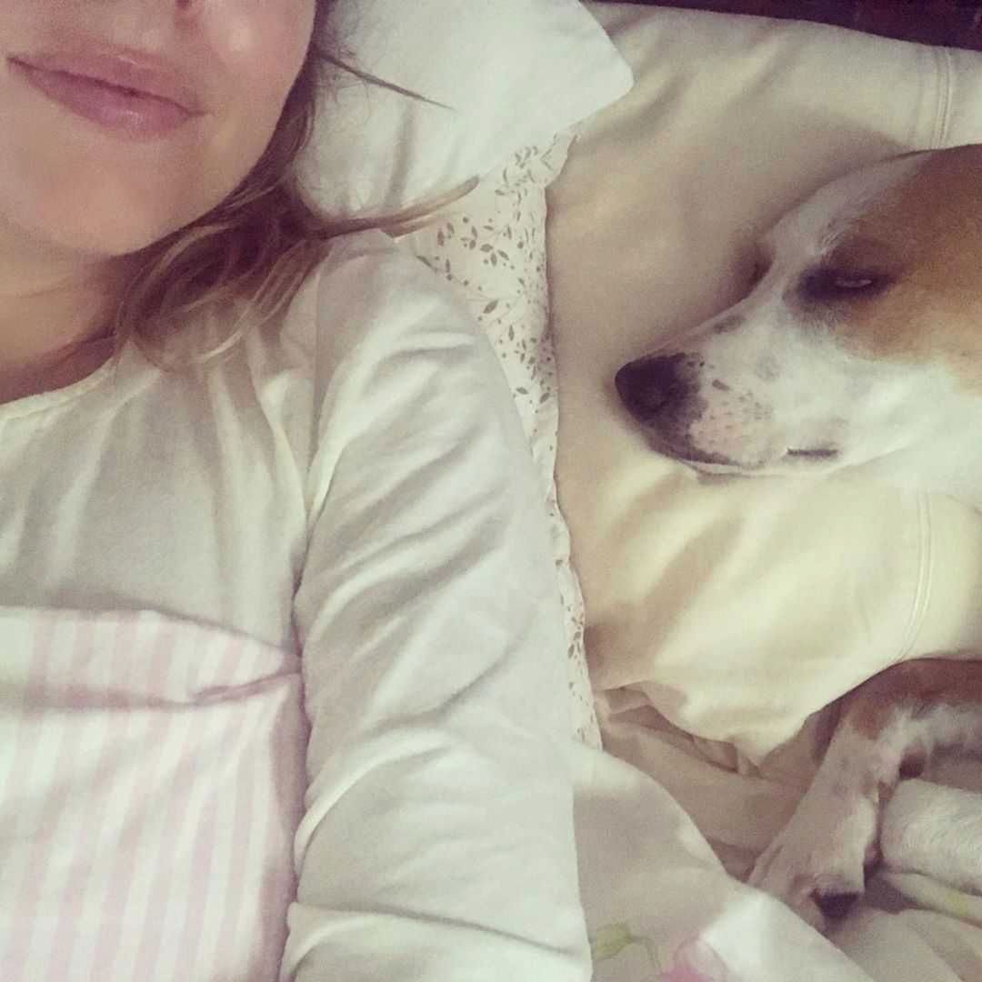 Aleksandra Kwaśniewska w łóżku z psem