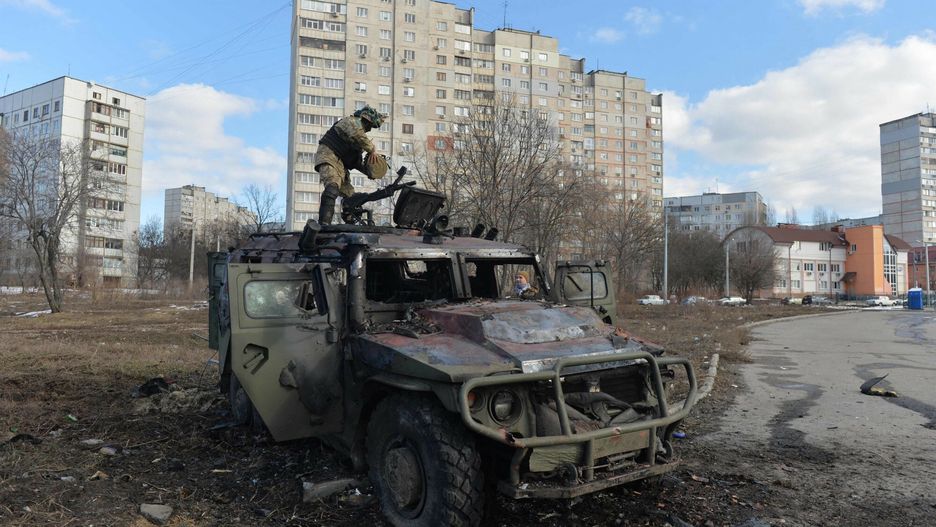 Rosja zaatakowa?a Ukrain?TOPSHOT - An Ukrainian Territorial Defence fighter examines a destroyed Russian infantry mobility vehicle GAZ Tigr after the fight in Kharkiv on February 27, 2022. - Ukrainian forces secured full control of Kharkiv on February 27, 2022 following street fighting with Russian troops in the country's second biggest city, the local governor said. (Photo by Sergey BOBOK / AFP)SERGEY BOBOK