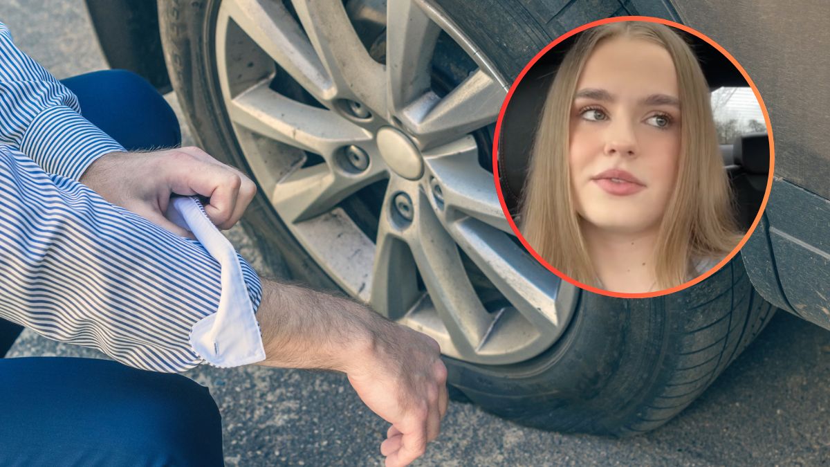 Mężczyzna schyla się do opony auta.