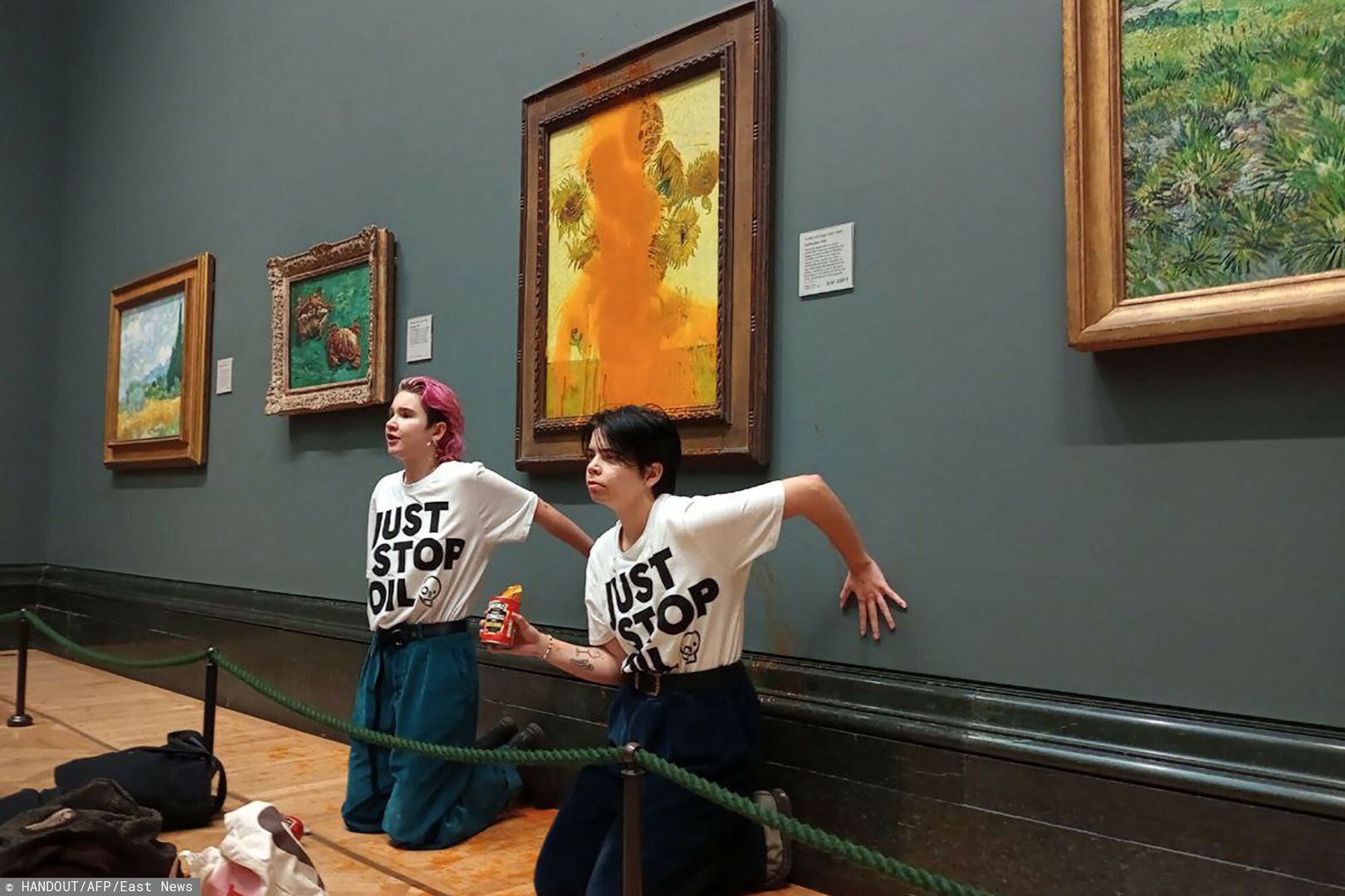 Temporary
A handout picture from the Just Stop Oil climate campaign group shows activists with their hands glued to the wall under Vincent van Gogh's "Sunflowers" after throwing tomato soup on the painting at the National Gallery in central London on October 14, 2022. - London's Metropolitan Police said its officers arrested two protesters from the Just Stop Oil group for criminal damage and aggravated trespass after they "threw a substance over a painting" at the gallery on Trafalgar Square. (Photo by Handout / Just Stop Oil / AFP) / RESTRICTED TO EDITORIAL USE - MANDATORY CREDIT "AFP PHOTO /  JUST STOP OIL " - NO MARKETING - NO ADVERTISING CAMPAIGNS - DISTRIBUTED AS A SERVICE TO CLIENTS
HANDOUT