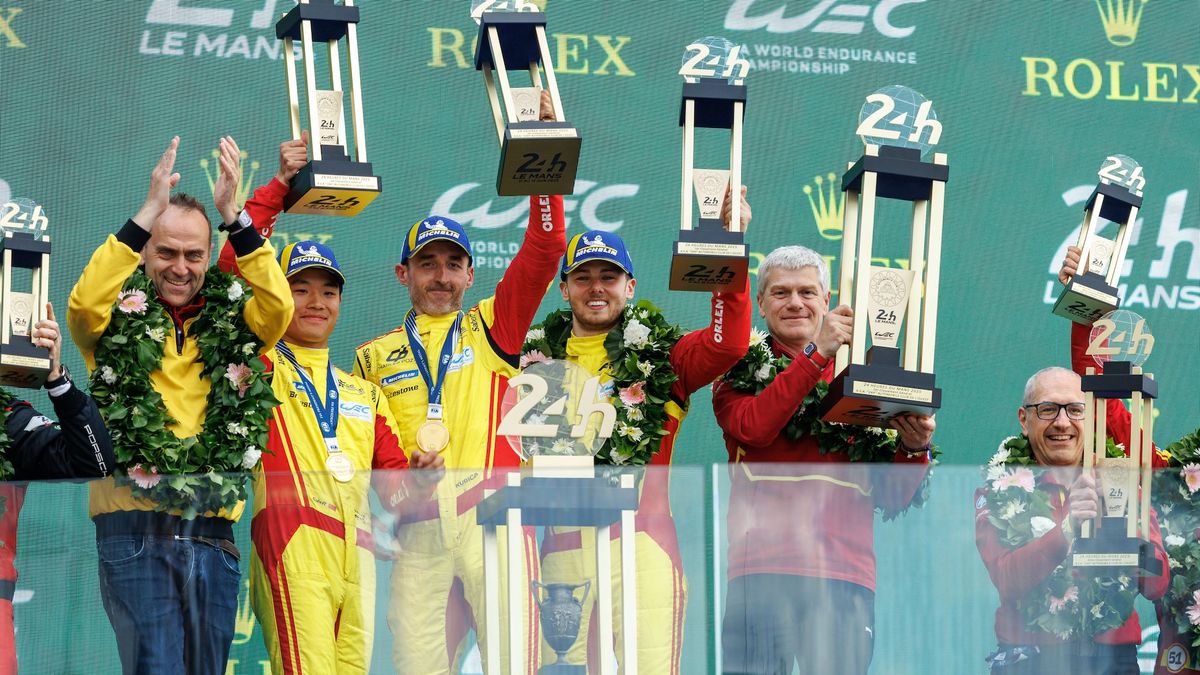 Robert Kubica wraz z zespołem i trofeami za zwycięstwo