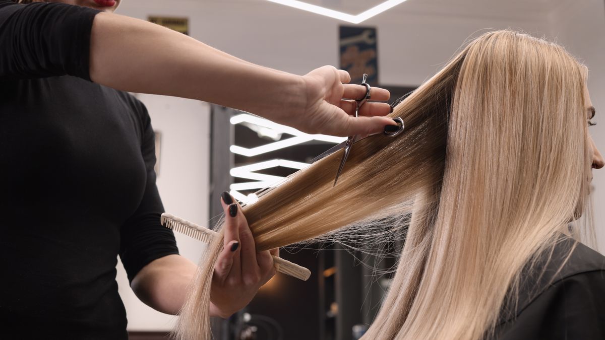 Kobieta z długimi włosami ścina włosy u fryzjera