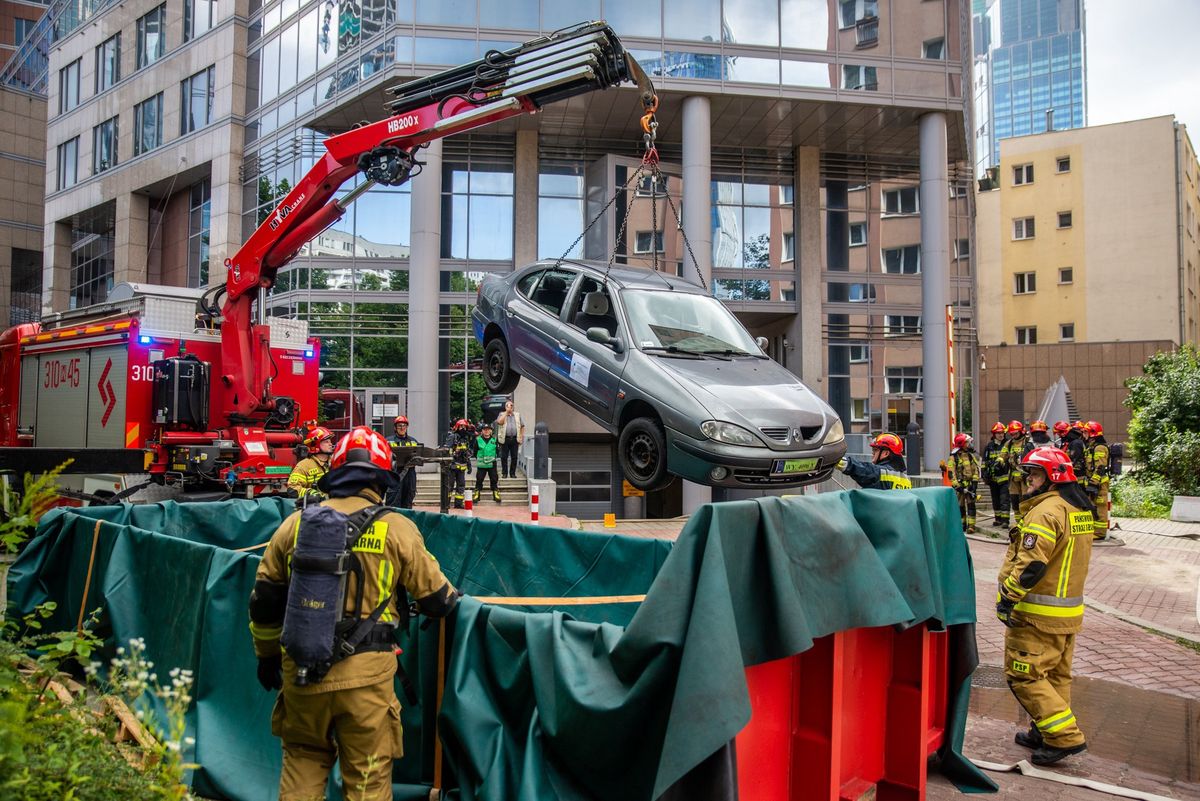 Warszawa. Spokojnie, to tylko ćwiczenia. Strażacy gasili elektryczny samochód. Trzeba było go jednak potem umieścić w kontenerze i zalać wodą, bowiem takie pojazdy mają tendencję do ponownego zapłonu po pożarze