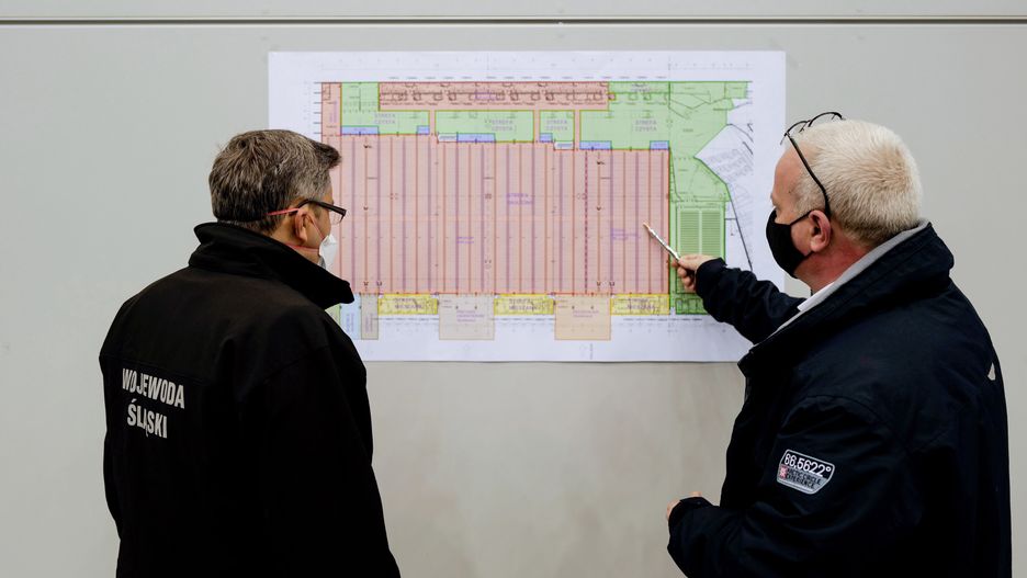 Wojewoda śląski Jarosław Wieczorek (L) i dyrektor szpitala MSWiA (P) na budowie szpitala polowego w hali Międzynarodowego Centrum Konferencyjnego w Katowicach.