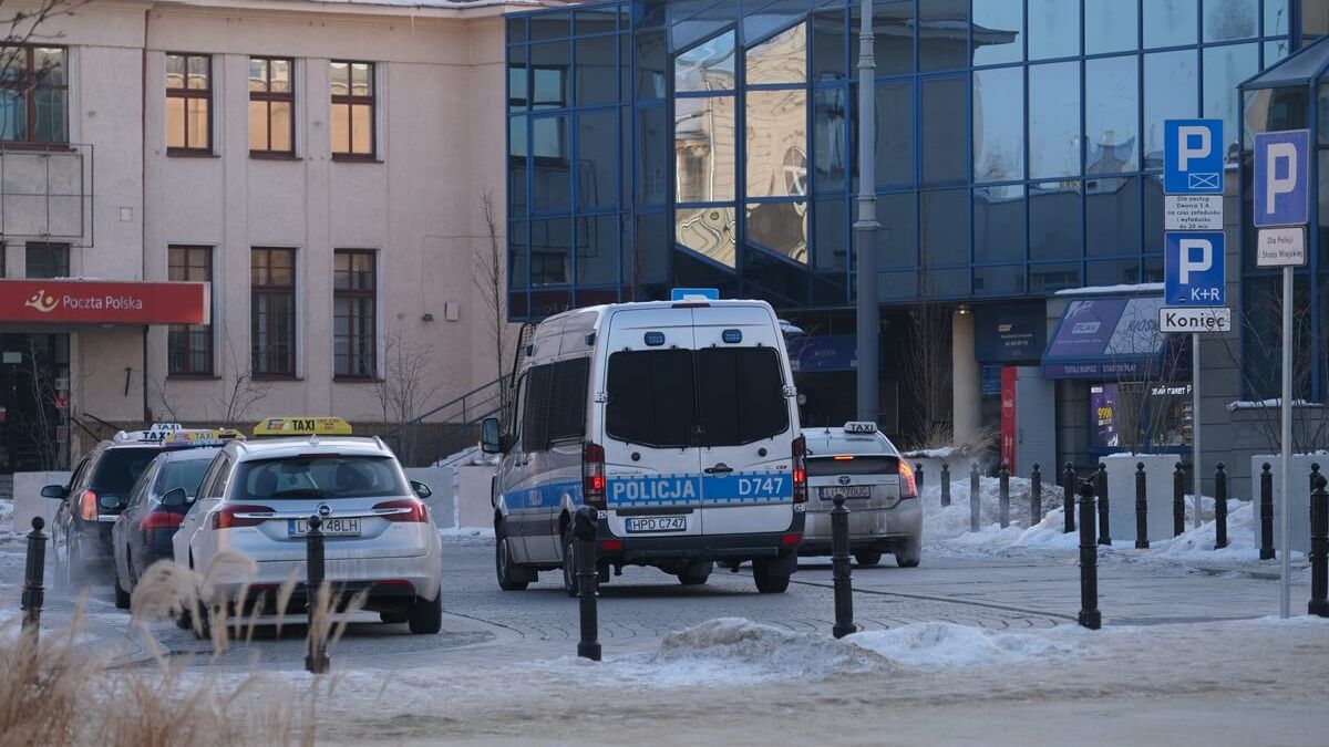 Taksówki i radiowóz policji przed dworcem PKP