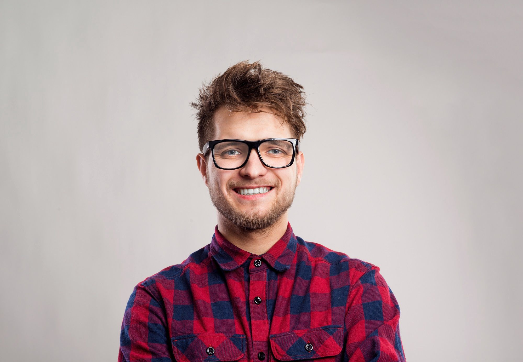 Man in checked shirt and eyeglasses against gray background.Hipster man in red checked shirt and eyeglasses. Studio shot on gray backgroundman, t-shirt, male, fashion, handsome, young, model, portrait, guy, white, casual, background, adult, standing, person, hair, one, confident, looking, stylish, people, black, studio, style, posing, cheerful, confidence, trendy, positive, cool, face, hipster, hairstyle, hairdo, haircut, beard, mustache, long sleeve, studio shot, concept, idea, smiling, gray, eyeglasses, red, checked, shirt, man, t-shirt, male, fashion, handsome, young, model, portrait, guy, white, casual, background, adult, standing, person, hair, one, confident, looking, stylish, people, black, studio, style, posing, cheerful, confidence, trendy, positive, cool, face, hipster, hairstyle, hairdo, haircut, beard, mustache, long sleeve, studio shot, concept, idea, smiling, gray, eyeglasses, red, checked, shirt