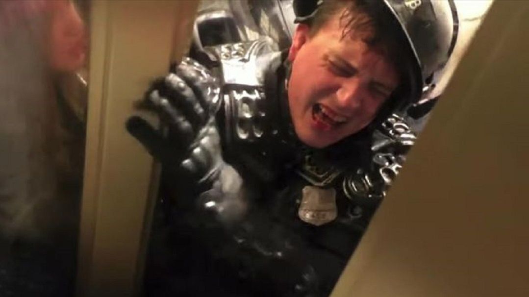 Zaklinowany w drzwiach policjant