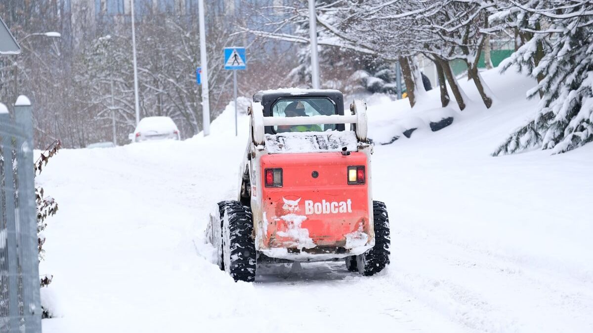 Miniładowarka odśnieżająca osiedlową uliczkę w Lublinie
