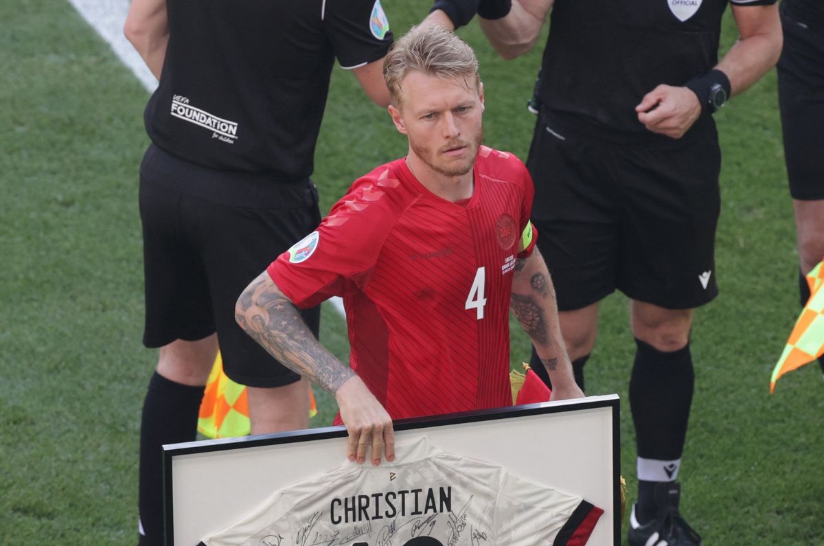 Kapitan drużyny Simon Kjaer trzyma ramkę koszulki poświęconej Christianowi Eriksenowi (PAP)