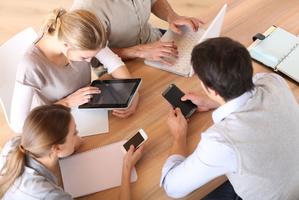 Group of business people using electronic devices at work