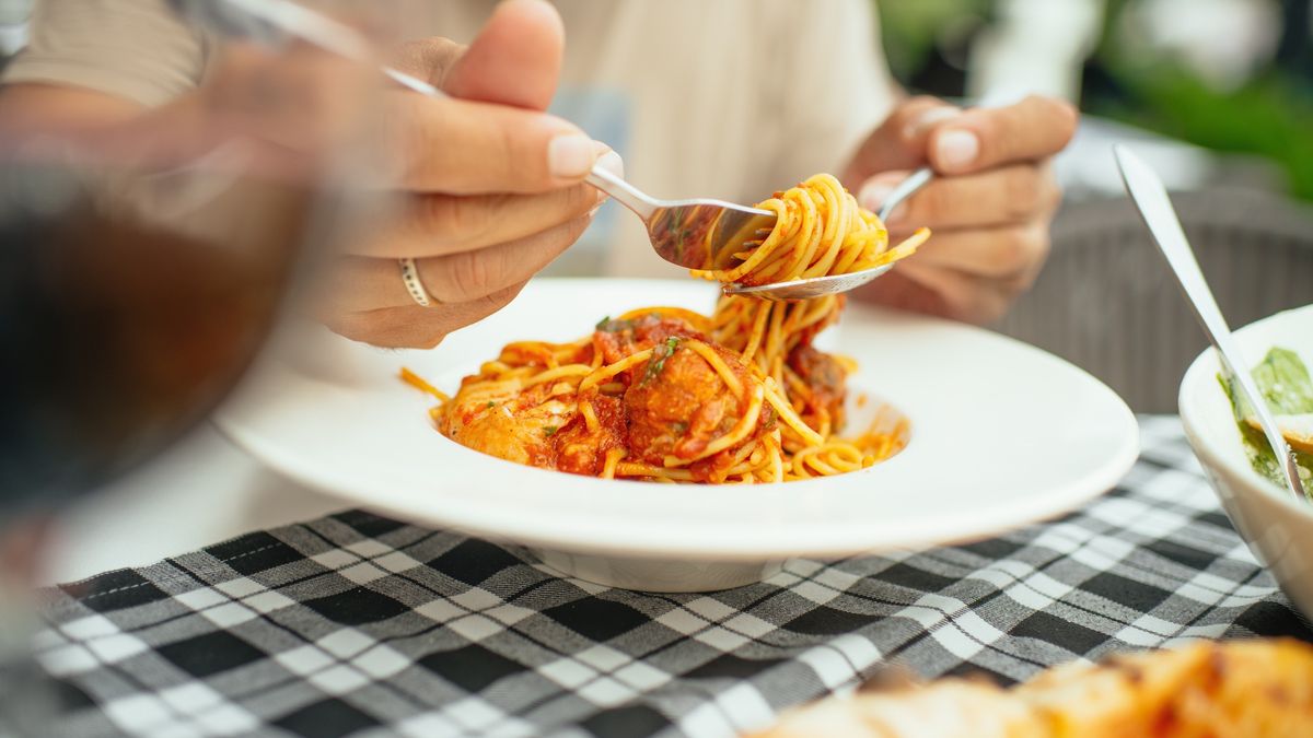 Man eating spaghetti pasta with meatballs
Spaghetti pasta with meatballs on a table in a cafe or restaurant
ArtMarie