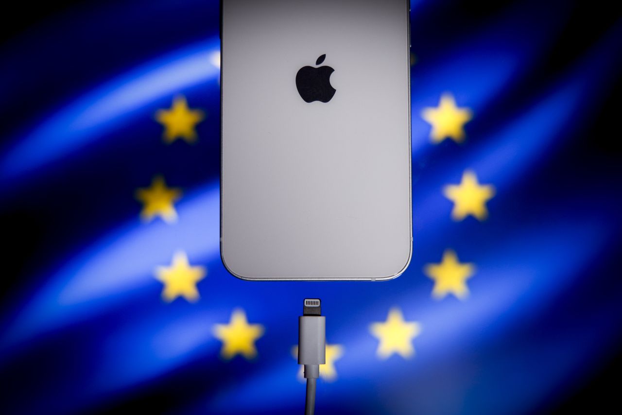 A Apple Lightning port charging cable is seen with with an iPhone with the EU flag in the backgrou (STR/NurPhoto via Getty Images)