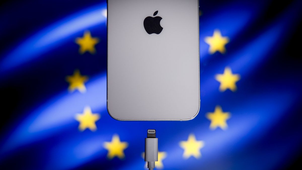 A Apple Lightning port charging cable is seen with with an iPhone with the EU flag in the background in this illustration photo in Warsaw, Poland on 05 October, 2022. The EU on Tuesday passed a law  enforcing USB-C as a standard for charging ports on electronic devices as of 2024. The move is especially critical for Apple which for years has held on to its proprietary Lightning charging accessories for its popular iPhone. (Photo by STR/NurPhoto via Getty Images)
