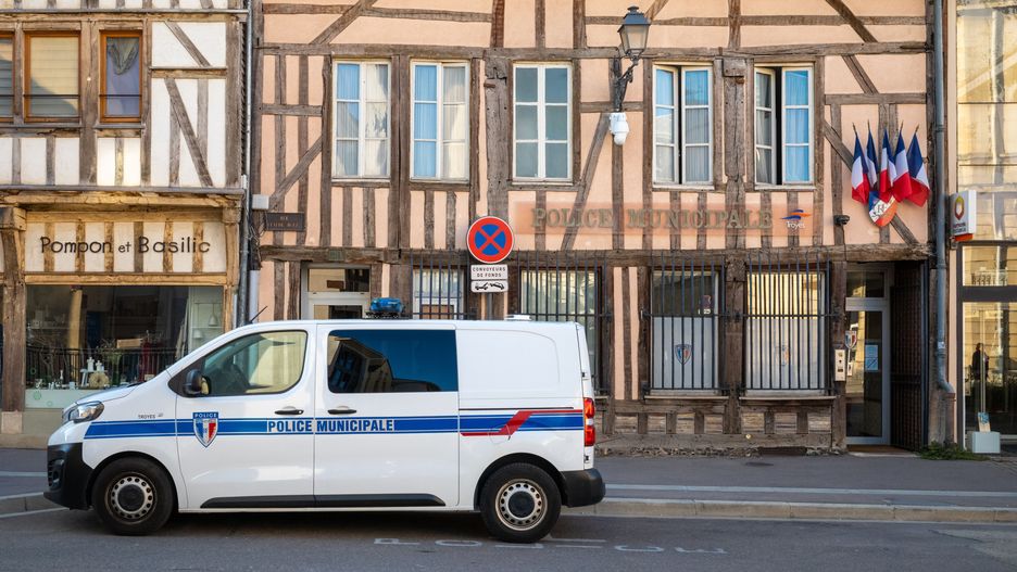 French tricolor flags fly outside the medieval building housing the municipal police station with a police van in Troyes, Aube, France. (Photo by: Andy Soloman/UCG/Universal Images Group via Getty Images)