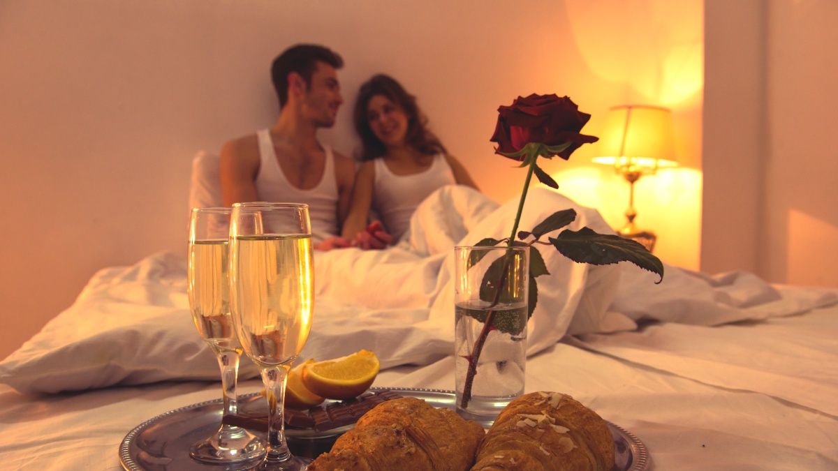 Zakochana para przytulająca się w białej pościeli