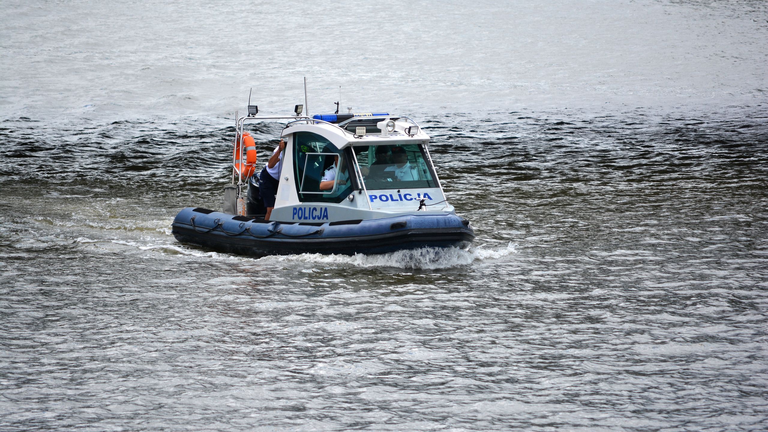 policyjna, motorówka, na rzece, policjant, policjantka, akcja, rzeka, na sygnale, prewencja, ratunek, tonie, topielec, funkcjonariusz, funkcjonariuszka, rejs, przewóz, ponton, napis policja, wybrzeże, odra, polska, police, policja, patrol, motorboat, z góry, ratuje, poszukiwania