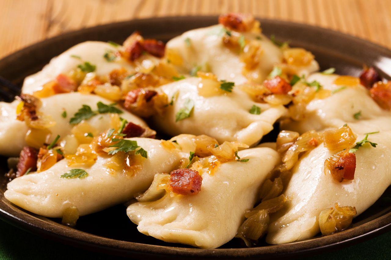 Pierogi po zbójnicku dopełnione dodatkiem cebuli i boczkiem