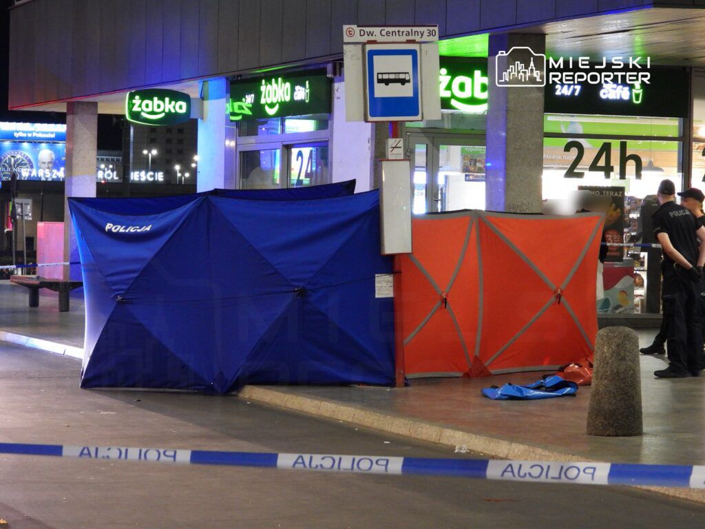 Policjanci pracują na miejscu zdarzenia, zabezpieczając teren przy sklepie całodobowym.