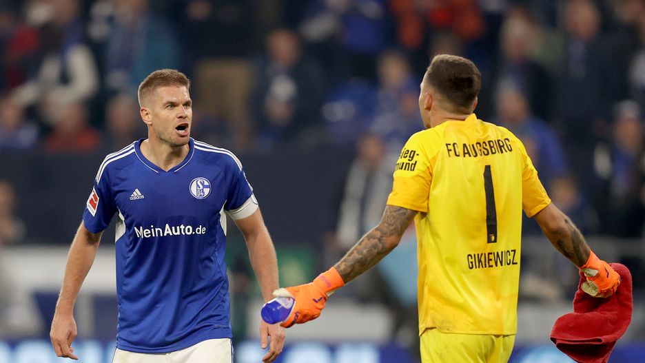 GELSENKIRCHEN, GERMANY - OCTOBER 02: Simon Terodde of FC Schalke 04 and Rafał Gikiewicz of Augsburg interact following the Bundesliga match between FC Schalke 04 and FC Augsburg at Veltins-Arena on October 02, 2022 in Gelsenkirchen, Germany. (Photo by Dean Mouhtaropoulos/Getty Images)