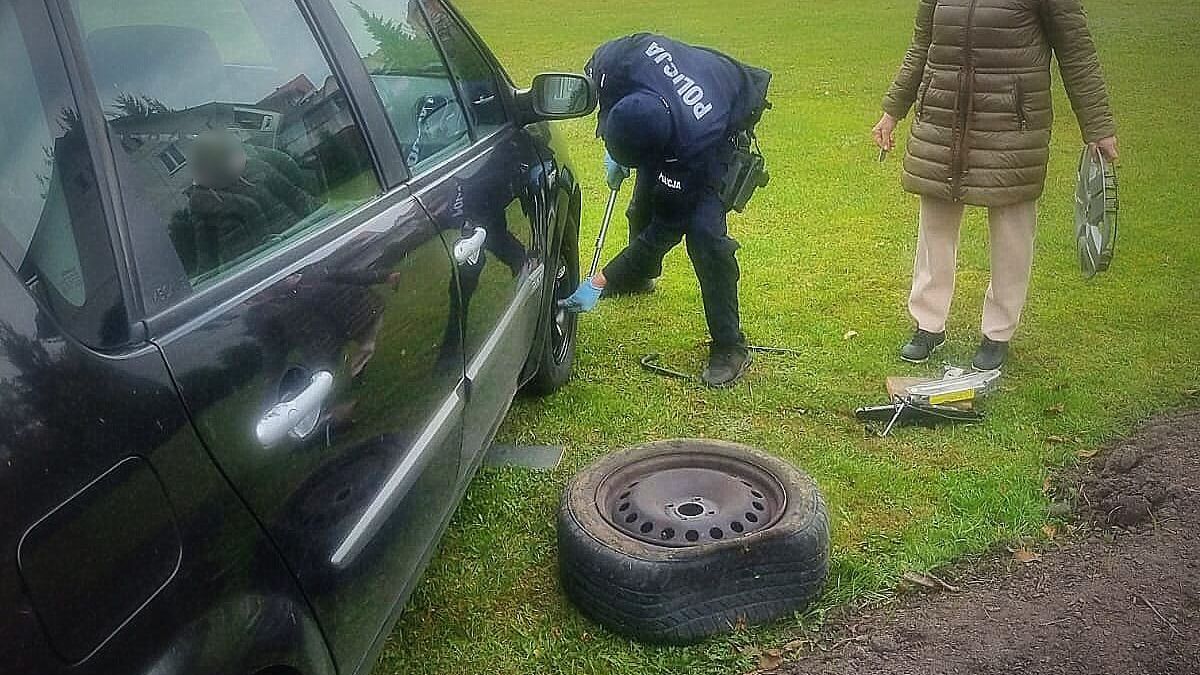 Policjant zmienia koło