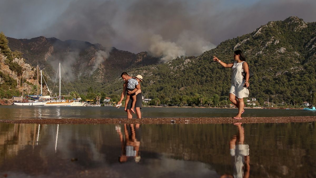 Wildfires in southern Turkeyepa09383263 People stand in the sea backdropped by the  wildfire burning in Marmaris district of Mugla, Turkey, 31 July 2021. According to a statement by the Turkish government's Disaster and Emergency Management Presidency (AFAD) released on 30 July 2021, at least three people lost their lives and some 271 others were affected by blazes that swept through the country's southern coast.  EPA/ERDEM SAHIN Dostawca: PAP/EPA.ERDEM SAHIN