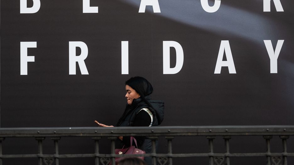 MADRID, SPAIN - 2024/11/25: A woman walks by a shop displaying a Black Friday sales sign. (Photo by Marcos del Mazo/LightRocket via Getty Images)