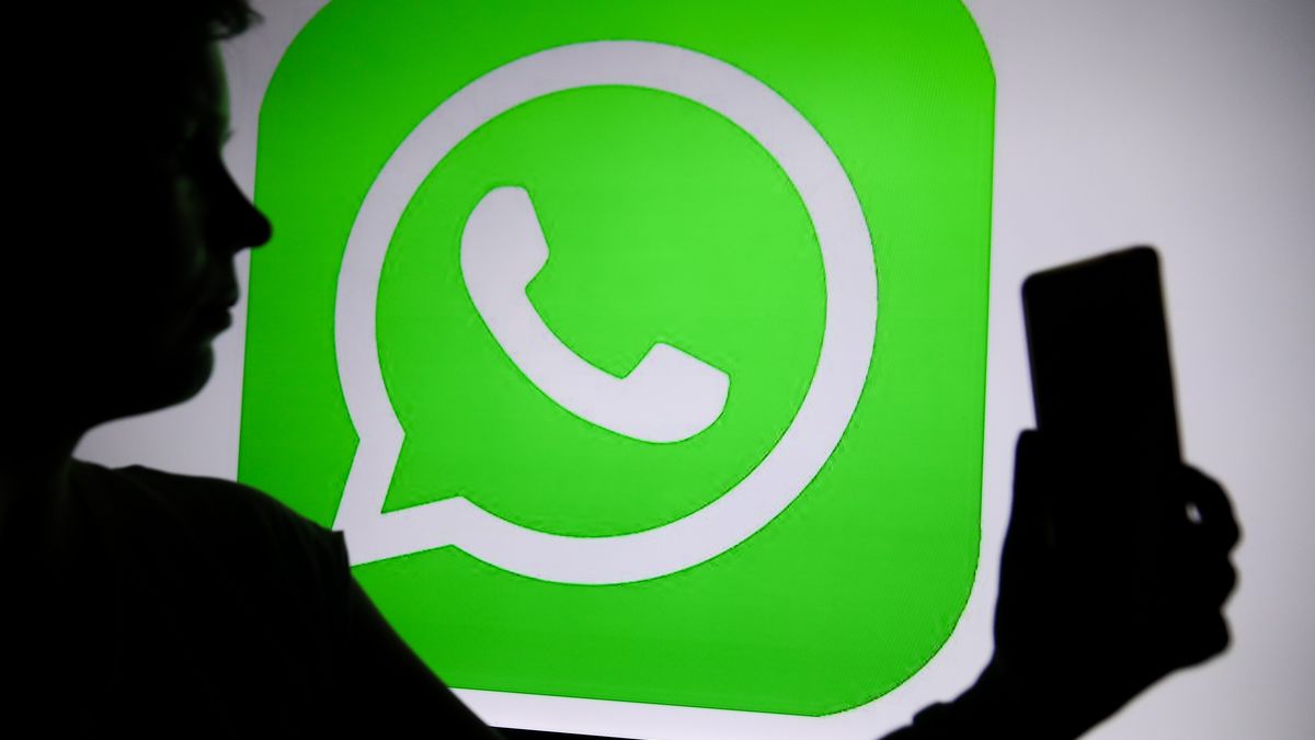 The WhatsApp logo with a person holding a phone in their hand is seen in Knurow, Poland, on April 20, 2025. (Photo Illustration by Klaudia Radecka/NurPhoto via Getty Images)