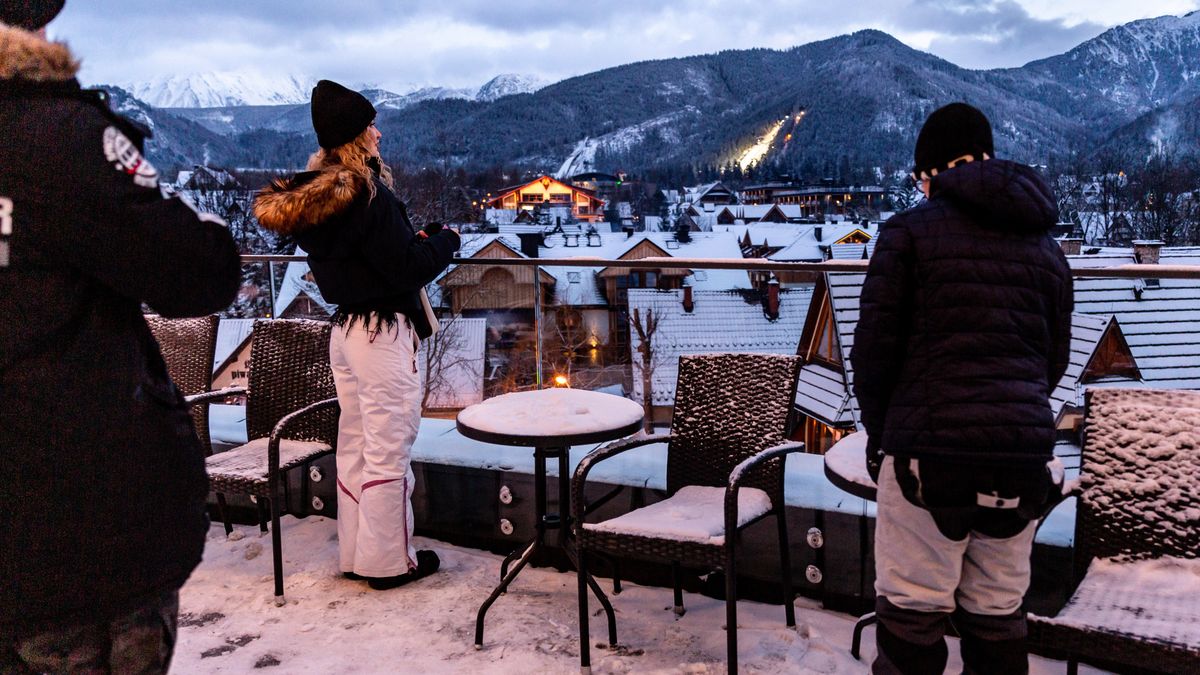 ZAKOPANE, MALOPOLSKIE, POLAND - 2024/01/19: Families look at a rooftop view of the mountain range along Krupowki Street in the center of Zakopane, a popular Tatra mountain holiday resort. (Photo by Dominika Zarzycka/SOPA Images/LightRocket via Getty Images)