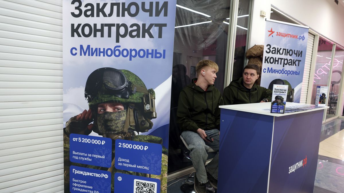 MOSCOW, RUSSIA - FEBRUARY 18: Recruiting staff for the Russian army to fight in the war against Ukraine sit next to propaganda posters in a shopping mall, on February 18, 2025, in Moscow, Russia. The sign reads: "Sign a contract with the Ministry of Defense. First-year pay starts at 5,200,000 rubles. First-month income is 2,500,000 rubles. Fast Russian citizenship application." (Photo by Contributor/Getty Images)